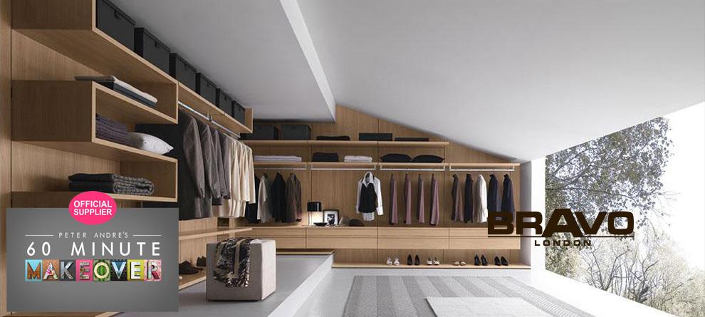 A modern walk-in closet with wooden shelving and drawers, featuring neatly organized clothes and accessories. A large window provides natural light. To the left, there is a logo for Peter Andres 60 Minute Makeover. On the right, the BRAVO London: showcases their expertise in walk-in wardrobes