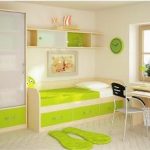 Bright and modern child's bedroom with a green and white color scheme, featuring a single bed, study desk with a computer, fitted wardrobes, and shelves. A window provides natural light.