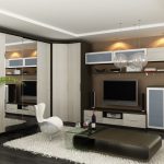 Modern living room with sleek furniture, a flat-screen TV, wooden cabinets including fitted bedrooms with hinged door wardrobes, and white accents, complemented by indoor plants and stylish hanging lights.
