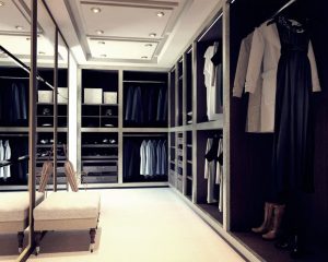 A luxurious walk-in wardrobe featuring an elegant array of clothing, shoes, and accessories, with plush seating and soft lighting.