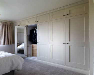 wardrobe door opened wide in a fitted bedroom