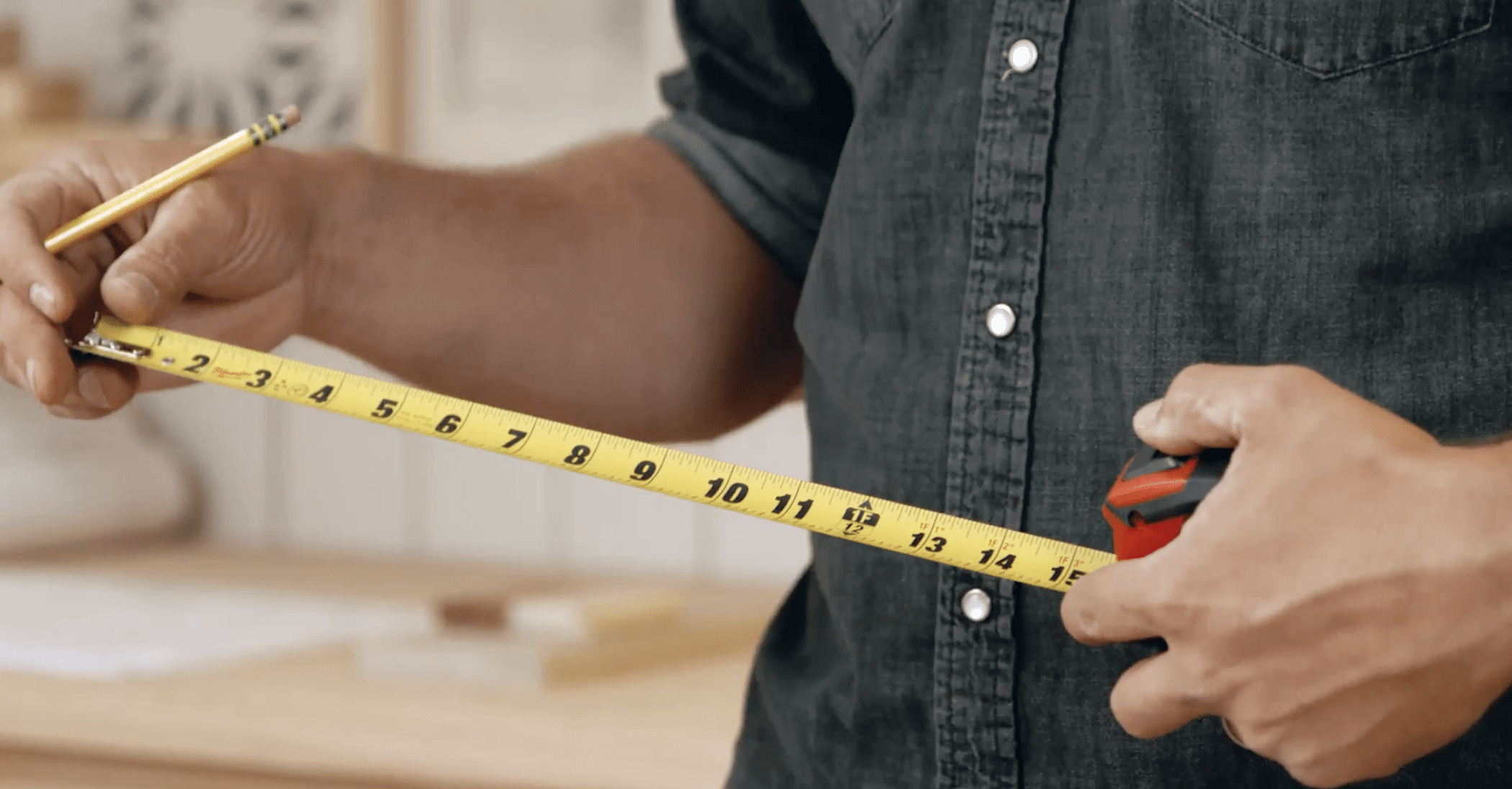 Professional preparing to take measurements for made to measure furniture production using a tape measure. 
